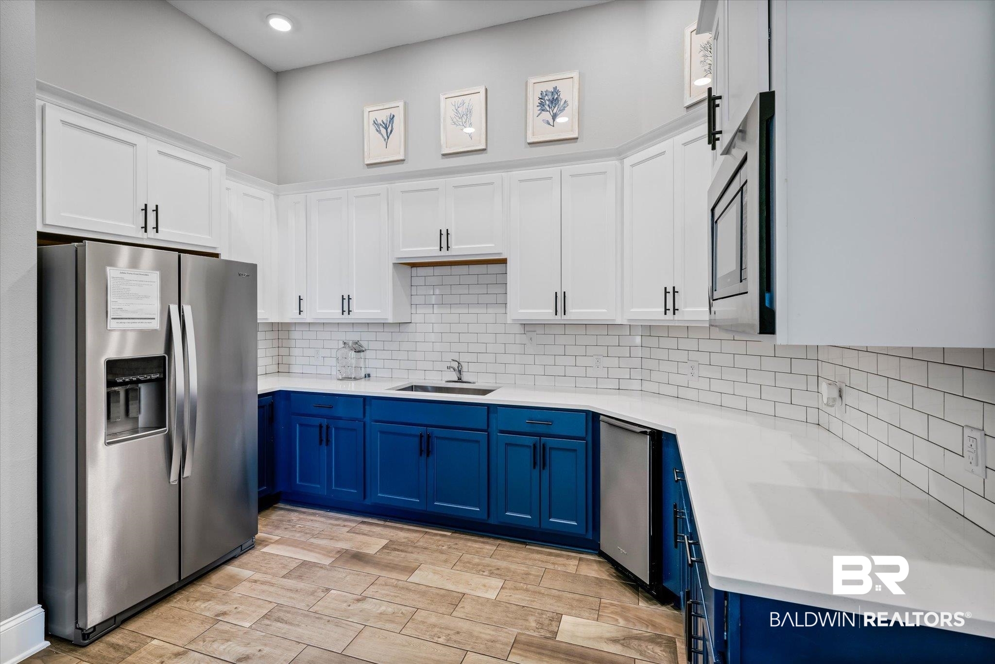 24262 Alydar Loop Daphne, AL 36526 - Photo 22 of 33 Kitchen with stainless steel fridge with ice dispenser, light countertops, blue cabinetry, white cabinetry, and a sink