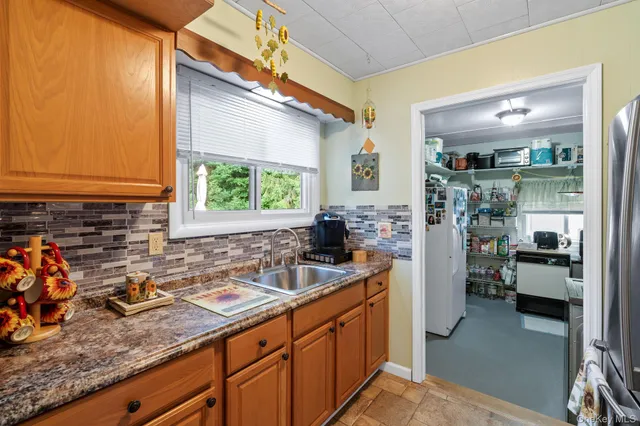 a kitchen with sink refrigerator and window