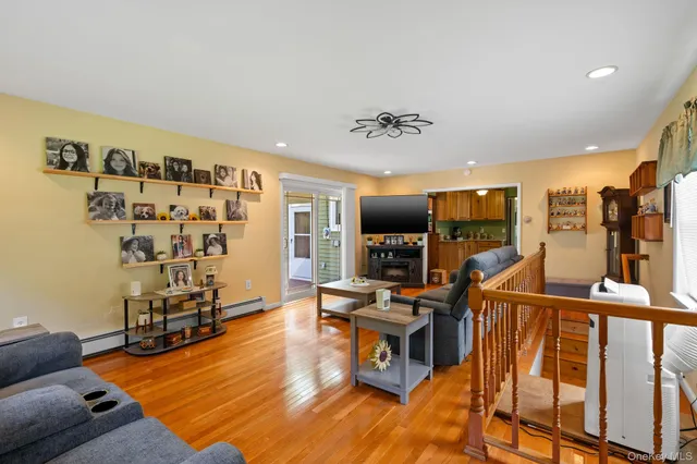 a living room with furniture a flat screen tv and wooden floor