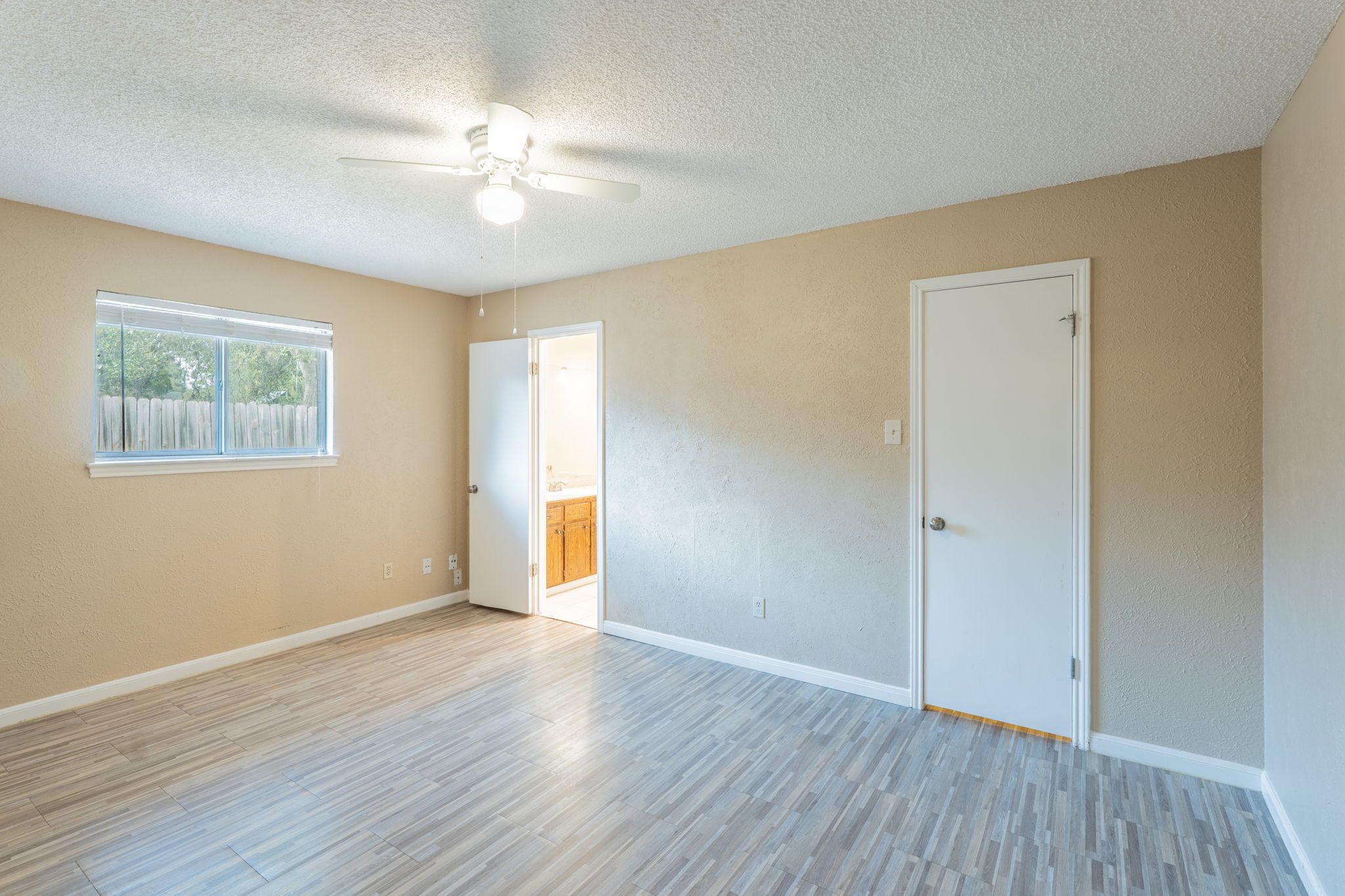 5628 Wagon Train Road Austin, TX 78749 - Photo 11 of 26 Gleaming wood-look tile floors and neutral walls anchor this comfortable bedroom space.