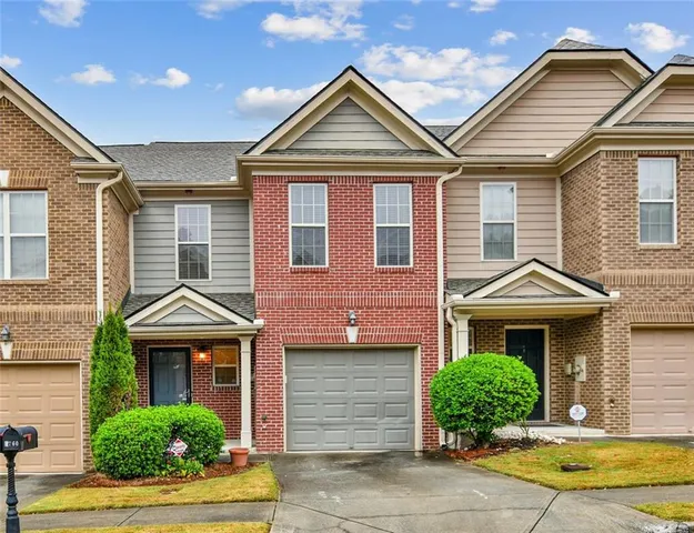 a front view of a house with a yard and potted plants