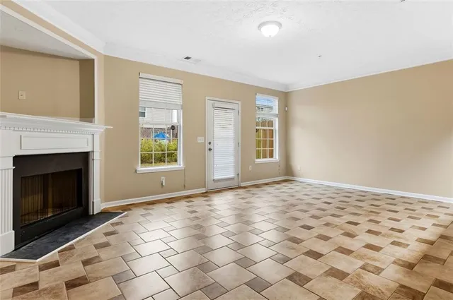 a view of an empty room with window and fire place