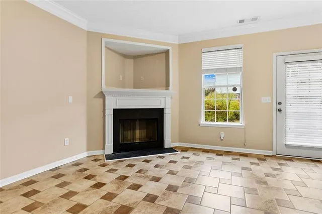 a view of empty room with a fireplace and window