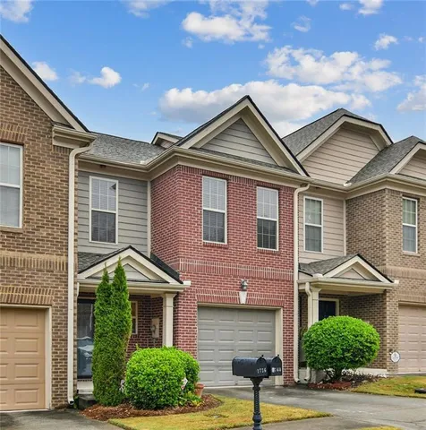a front view of a house with a yard and potted plants
