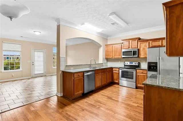 a large kitchen with wooden floors and stainless steel appliances