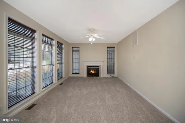 a view of an empty room with a fireplace and a window