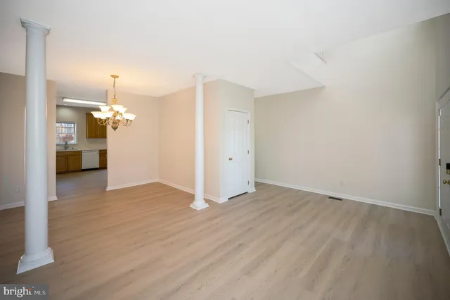 a view of a livingroom with wooden floor and a chandelier