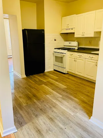 a kitchen with stainless steel appliances granite countertop a refrigerator a stove and white cabinets