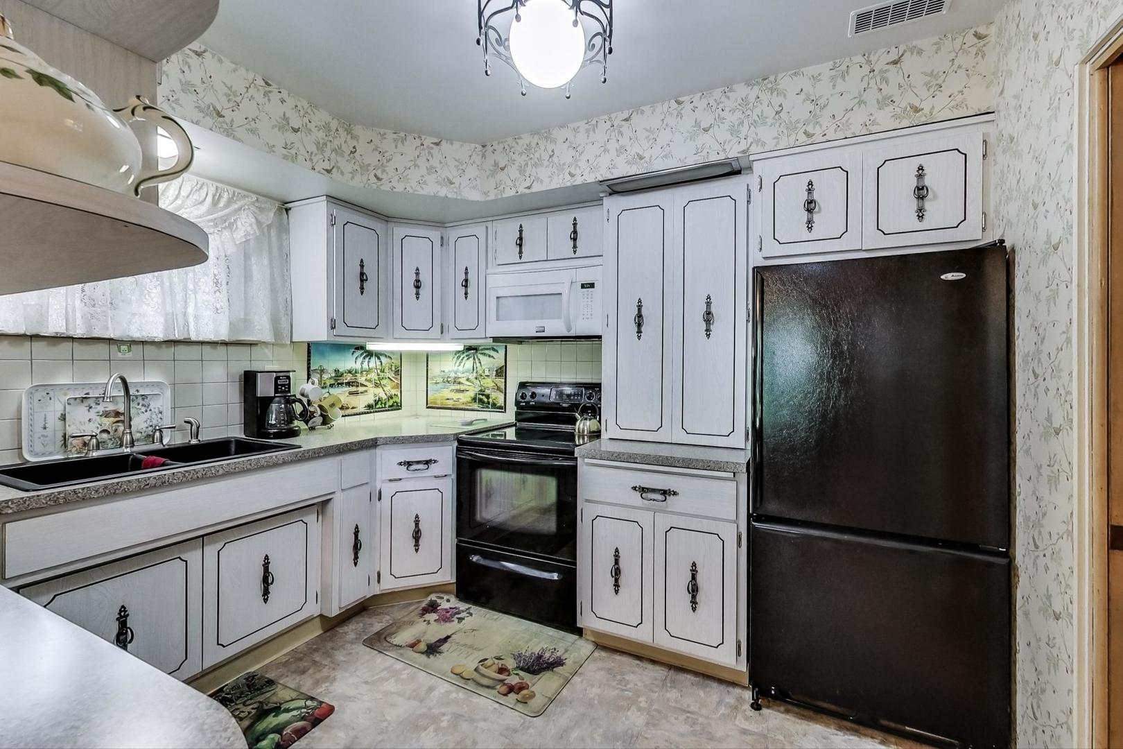 365 Lionel Road Riverside, IL 60546 - Photo 5 of 35 a kitchen with stainless steel appliances granite countertop a refrigerator a sink dishwasher a stove and white cabinets with wooden floor