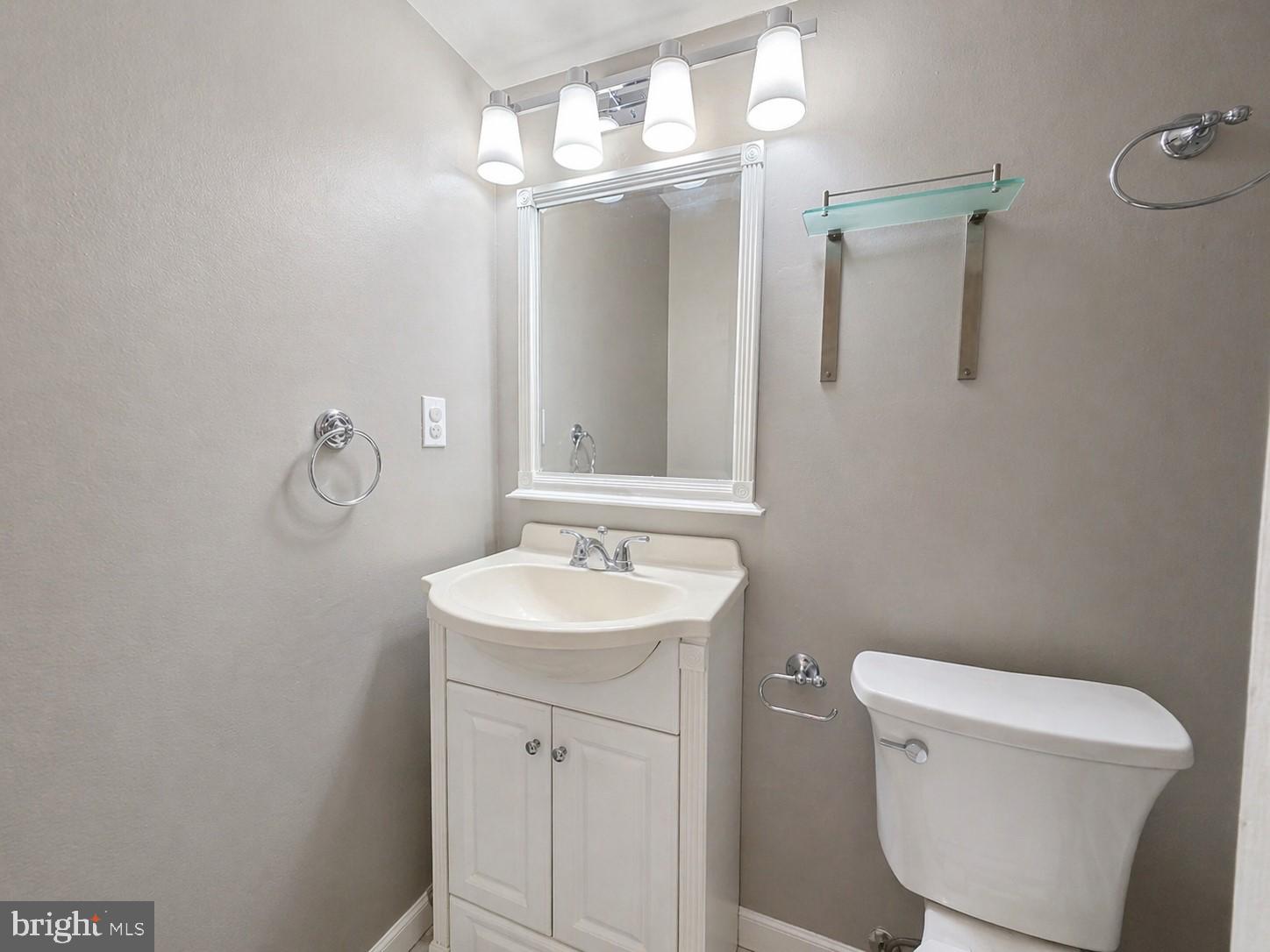 8353 Montgomery Run Road, Unit F Ellicott City, MD 21043 - Photo 15 of 25 a bathroom with a toilet a sink and mirror