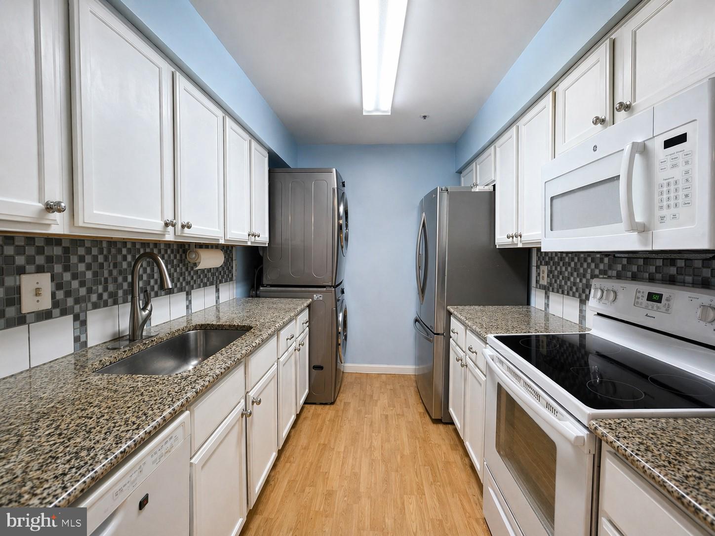 8353 Montgomery Run Road, Unit F Ellicott City, MD 21043 - Photo 8 of 25 a kitchen with granite countertop a sink a stove and refrigerator