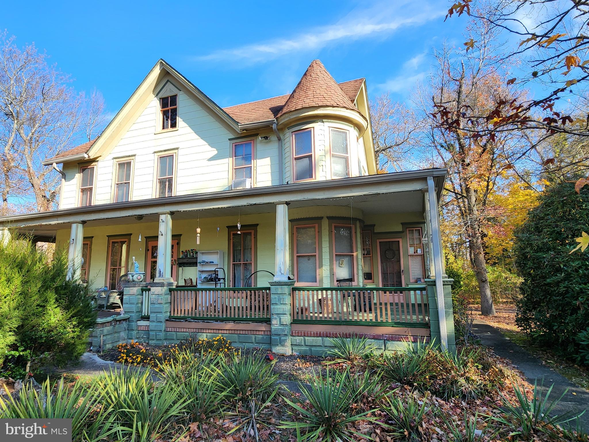 a view of a white house with large windows and a small yard