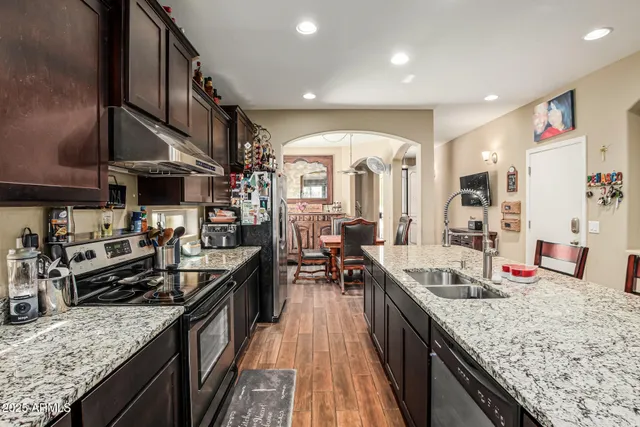 a kitchen with stainless steel appliances granite countertop sink stove top oven and cabinets