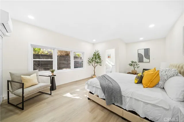 a spacious bedroom with a bed and wooden floor