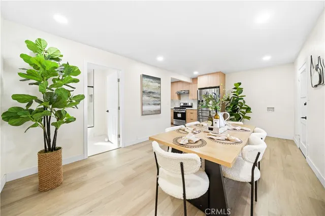 a dining room with furniture potted plants and wooden floor