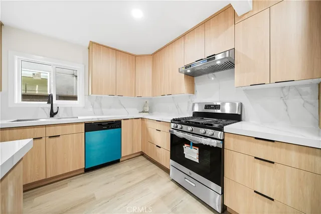 a kitchen with stainless steel appliances granite countertop a sink stove and cabinets