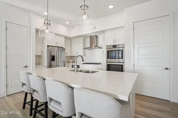 a kitchen with refrigerator and chairs
