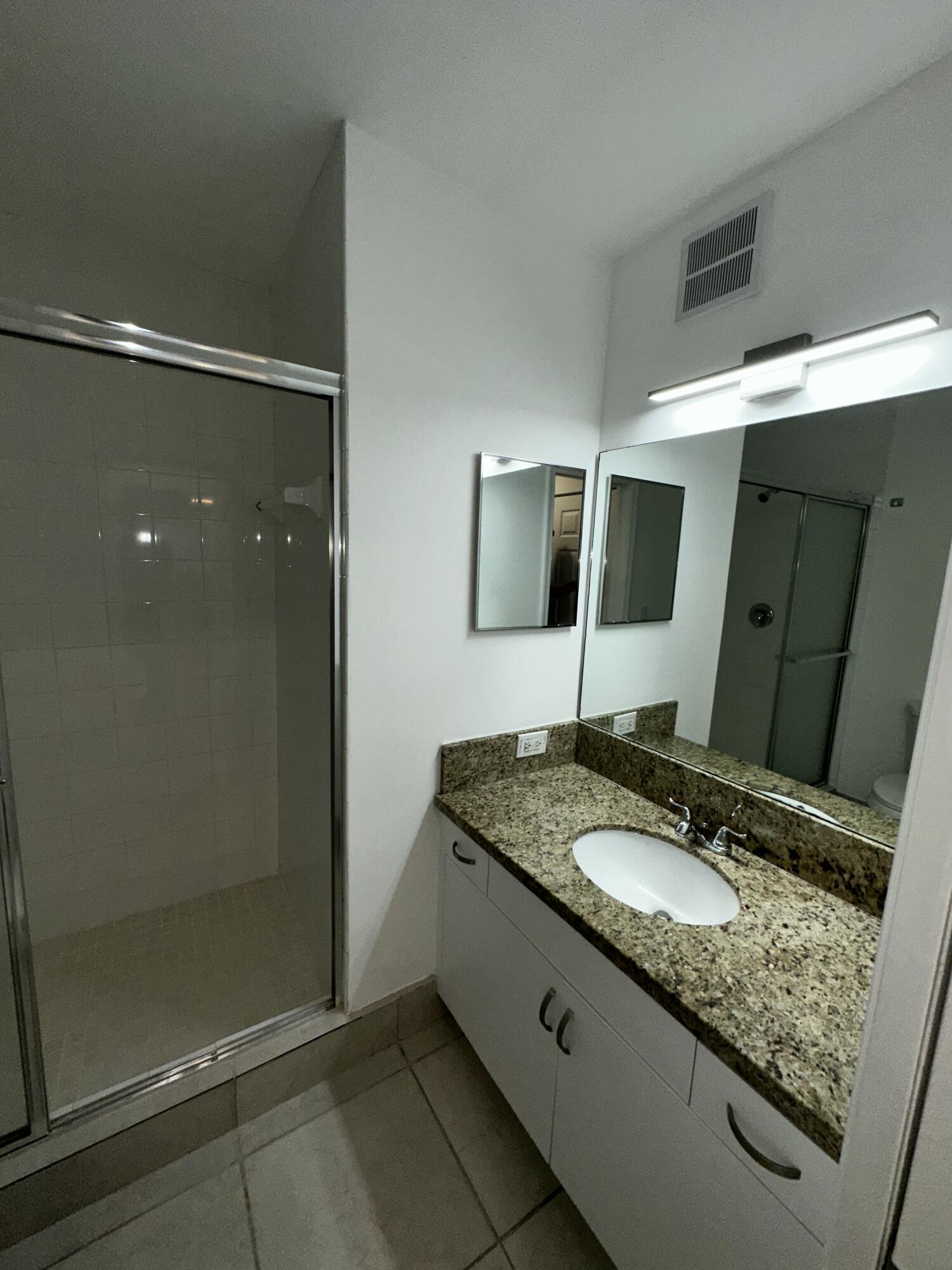 2103 Renaissance Boulevard, Unit 306 Miramar, FL 33025 - Photo 19 of 44 a bathroom with a granite countertop sink mirror and shower