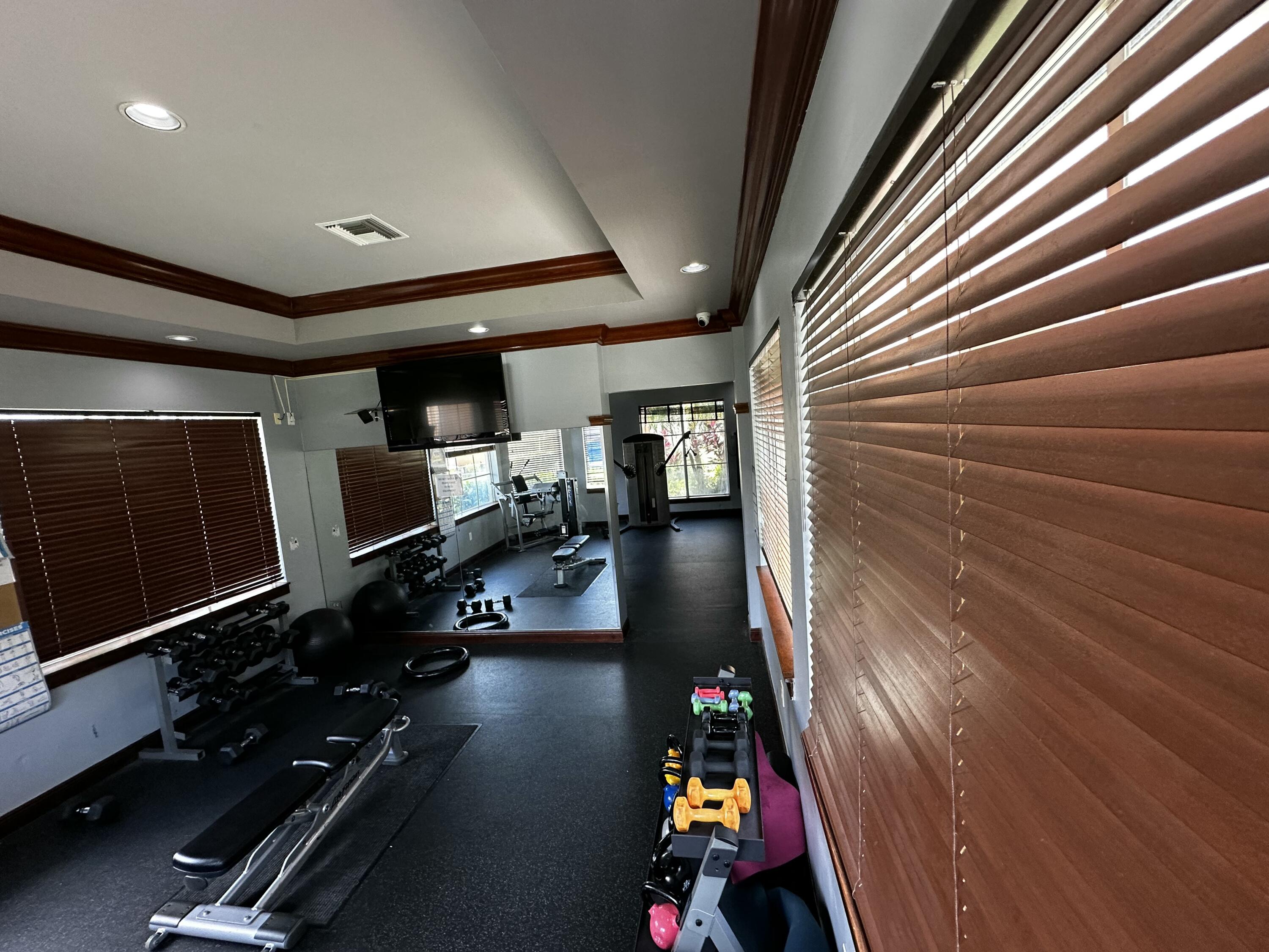 2103 Renaissance Boulevard, Unit 306 Miramar, FL 33025 - Photo 37 of 44 a room with gym equipment equipment wooden floor and windows