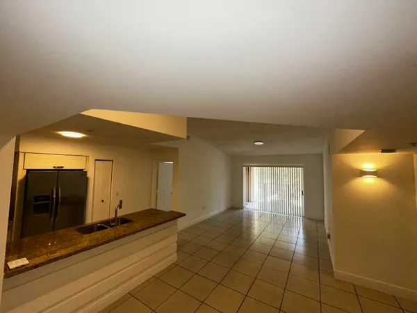 a view of a hallway with wooden floor and a bathroom