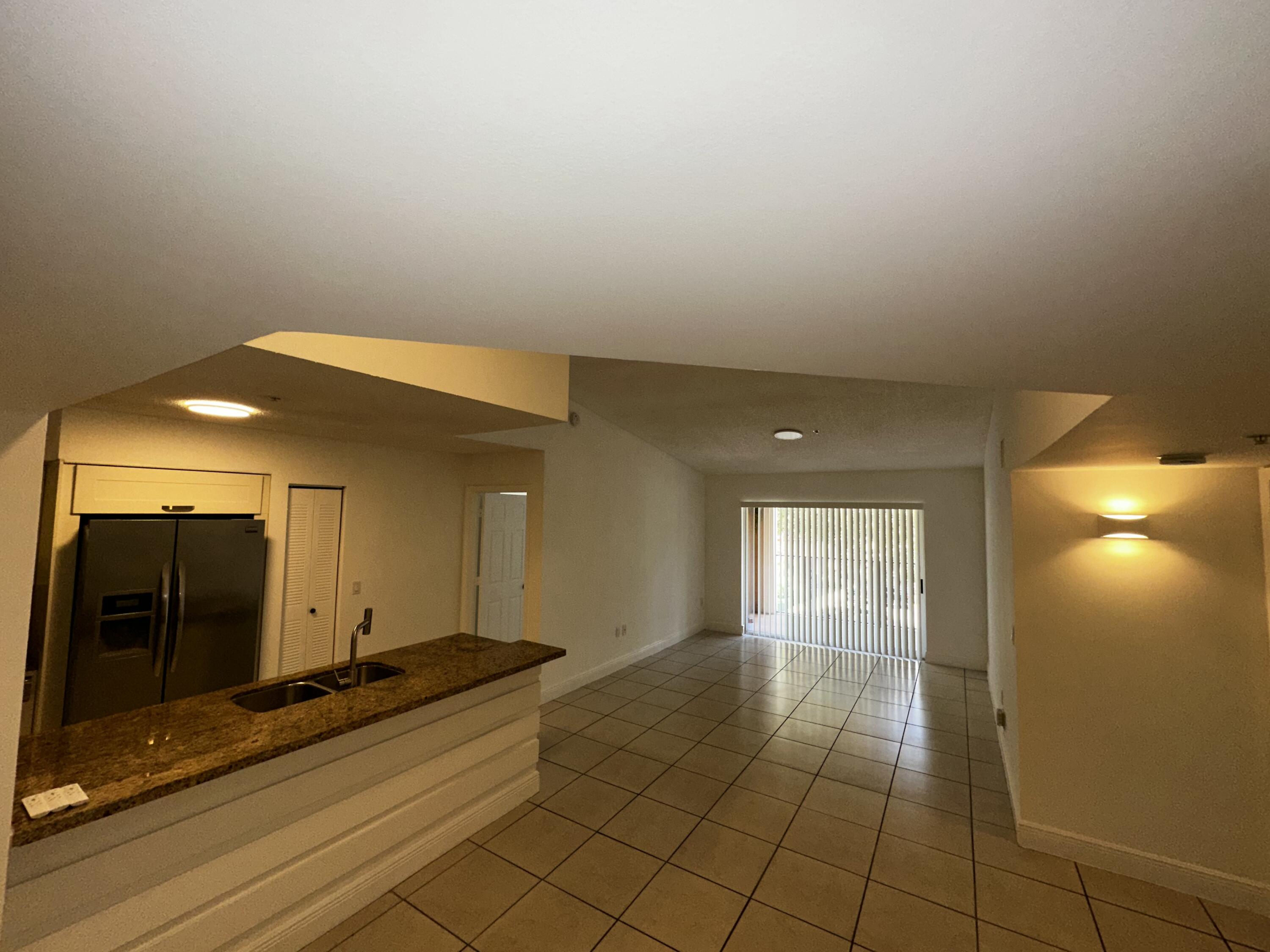 2103 Renaissance Boulevard, Unit 306 Miramar, FL 33025 - Photo 5 of 44 a view of a hallway with wooden floor and a bathroom