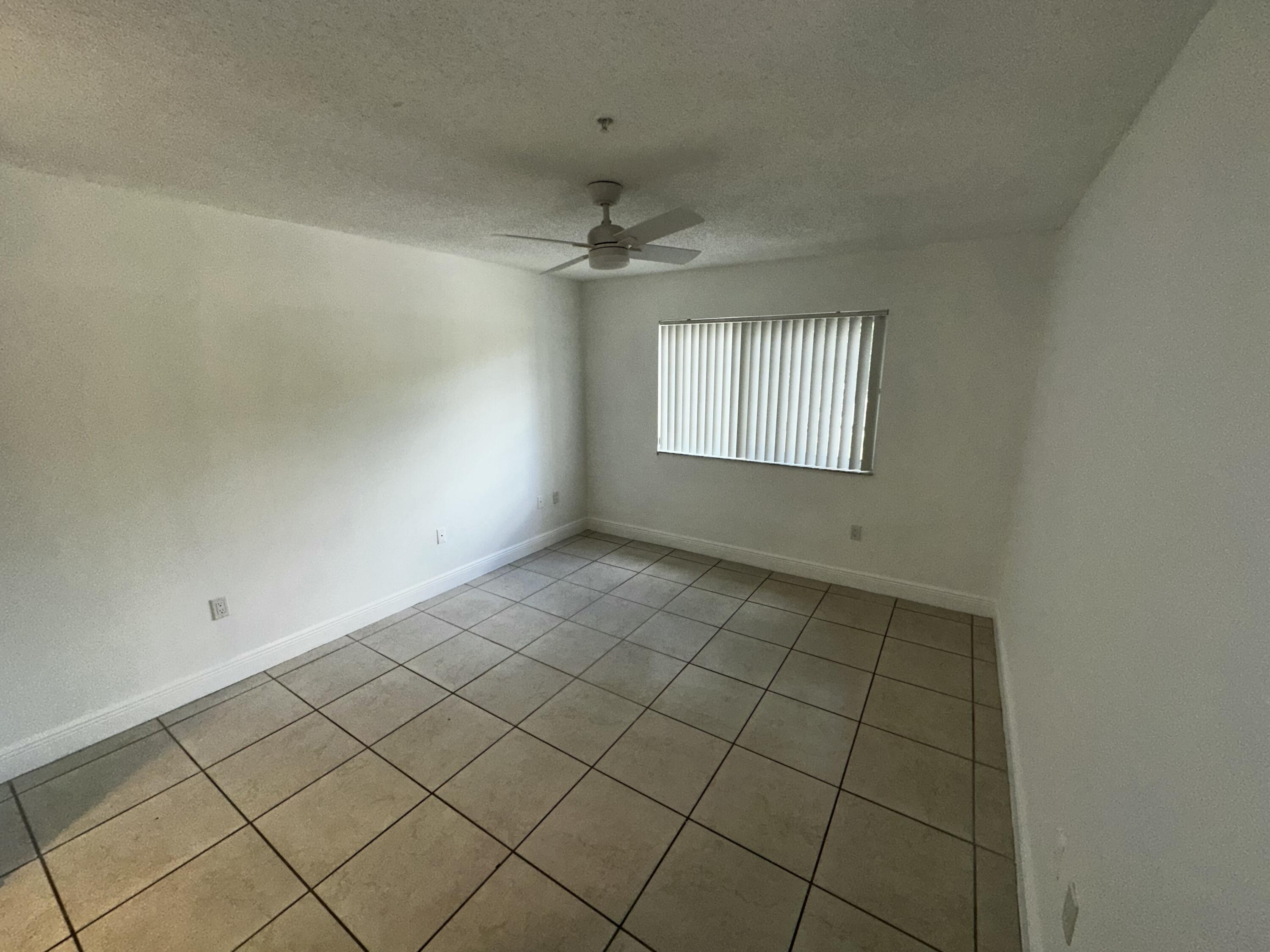 2103 Renaissance Boulevard, Unit 306 Miramar, FL 33025 - Photo 10 of 44 an empty room with windows and ceiling fan