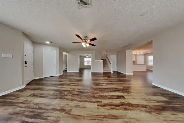 a view of empty room with wooden floor and window
