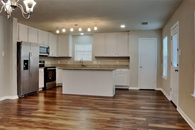a view of kitchen with granite countertop cabinets and stainless steel appliances