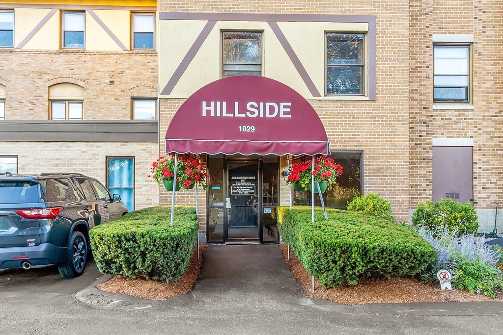 1029 Pleasant Street, Unit 19 Worcester, MA 01602 - Photo 1 of 23 a front view of a building with garden