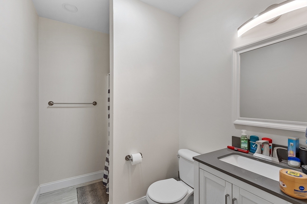1029 Pleasant Street, Unit 19 Worcester, MA 01602 - Photo 20 of 23 a bathroom with a granite countertop toilet sink and a mirror