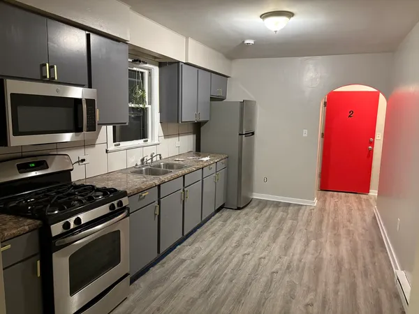 a kitchen with stainless steel appliances granite countertop a stove a sink and a refrigerator