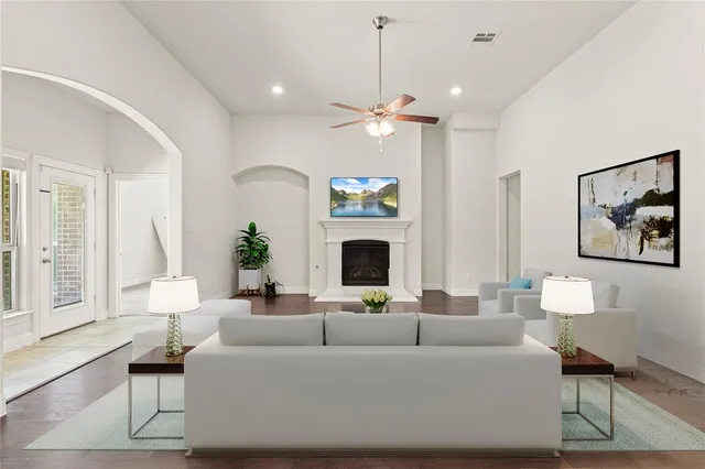 a living room with furniture a fireplace and a chandelier