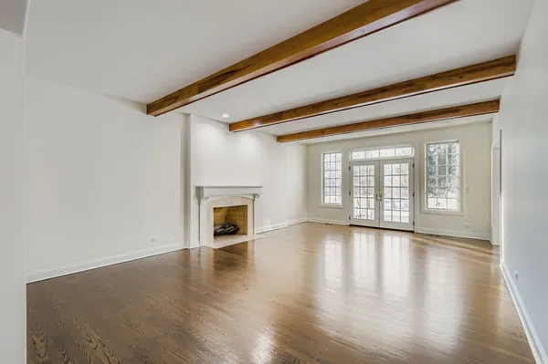 a view of empty room with wooden floor and fireplace