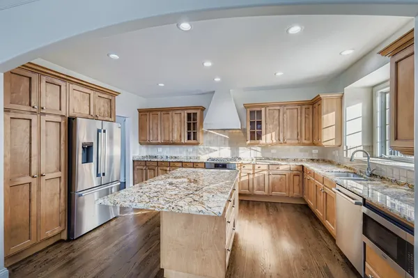 a kitchen with a refrigerator a sink and wooden cabinets