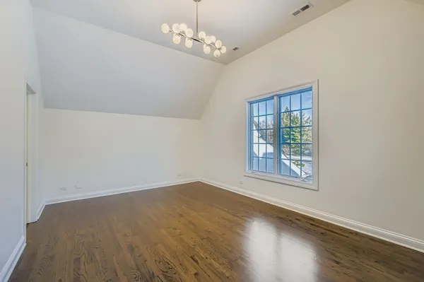 a view of an empty room with wooden floor and wooden floor