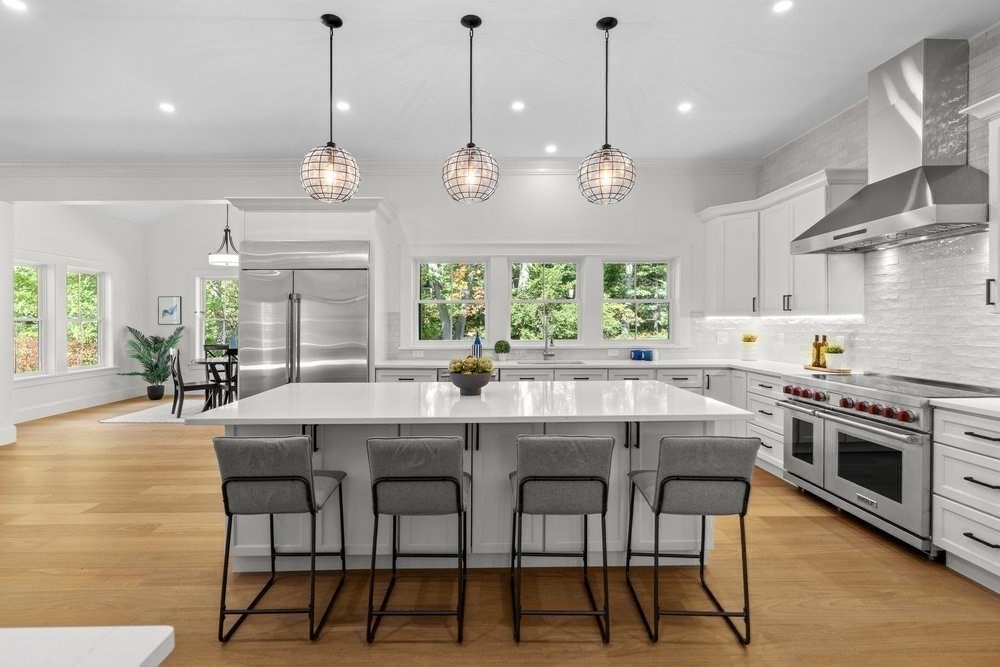22 Tyler Road Lexington, MA 02420 - Photo 9 of 37 a kitchen with stainless steel appliances granite countertop a stove top oven a refrigerator a kitchen island a dining table and chairs with wooden floor
