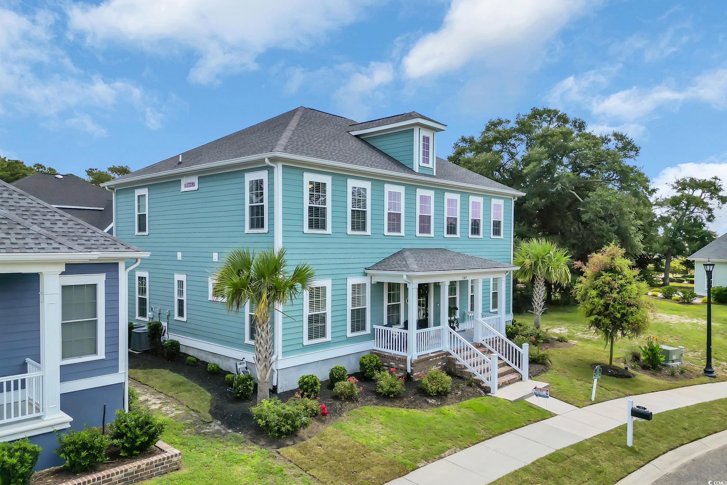 1307 Wading Heron Road North Myrtle Beach, SC 29582 - Photo 40 of 40 View of front of house featuring a porch, a front yard, and a shingled roof