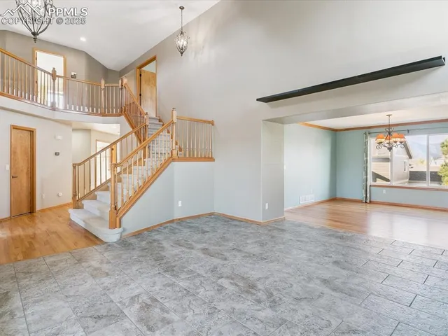 a view of a room with wooden floor and chandelier