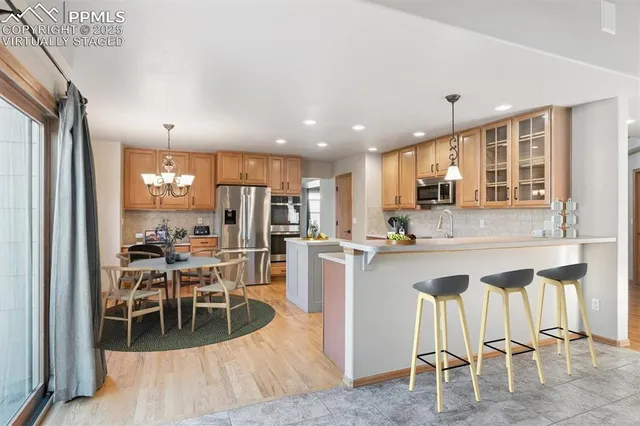 a kitchen with stainless steel appliances kitchen island granite countertop a refrigerator and cabinets