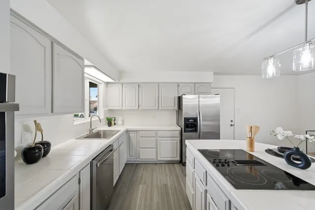 a kitchen filled a sink a refrigerator and cabinets