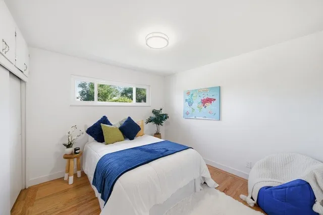 a bedroom with a bed and a painting on the wall