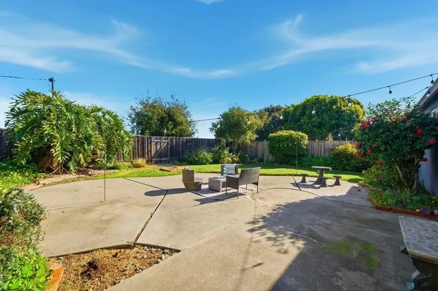 a view of a swimming pool with a lounge chair and grass