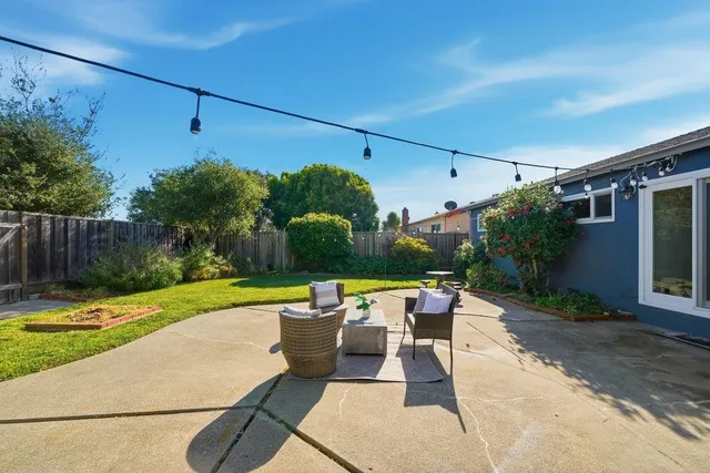 a view of a patio with table and chairs potted plants with wooden fence