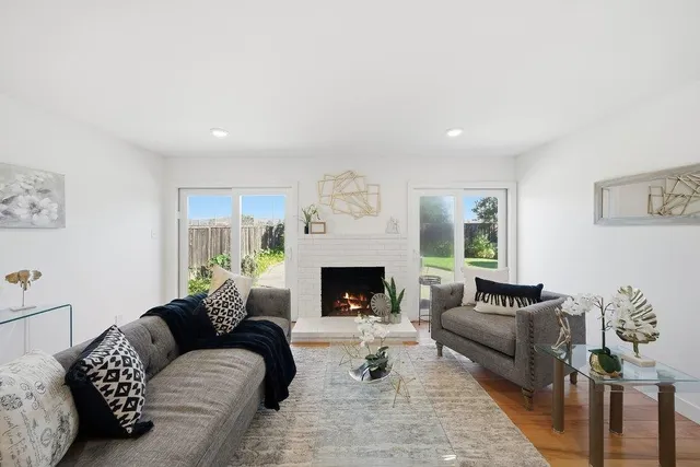 a living room with furniture a fireplace and a large window