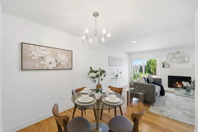a view of a dining room with furniture a chandelier and wooden floor