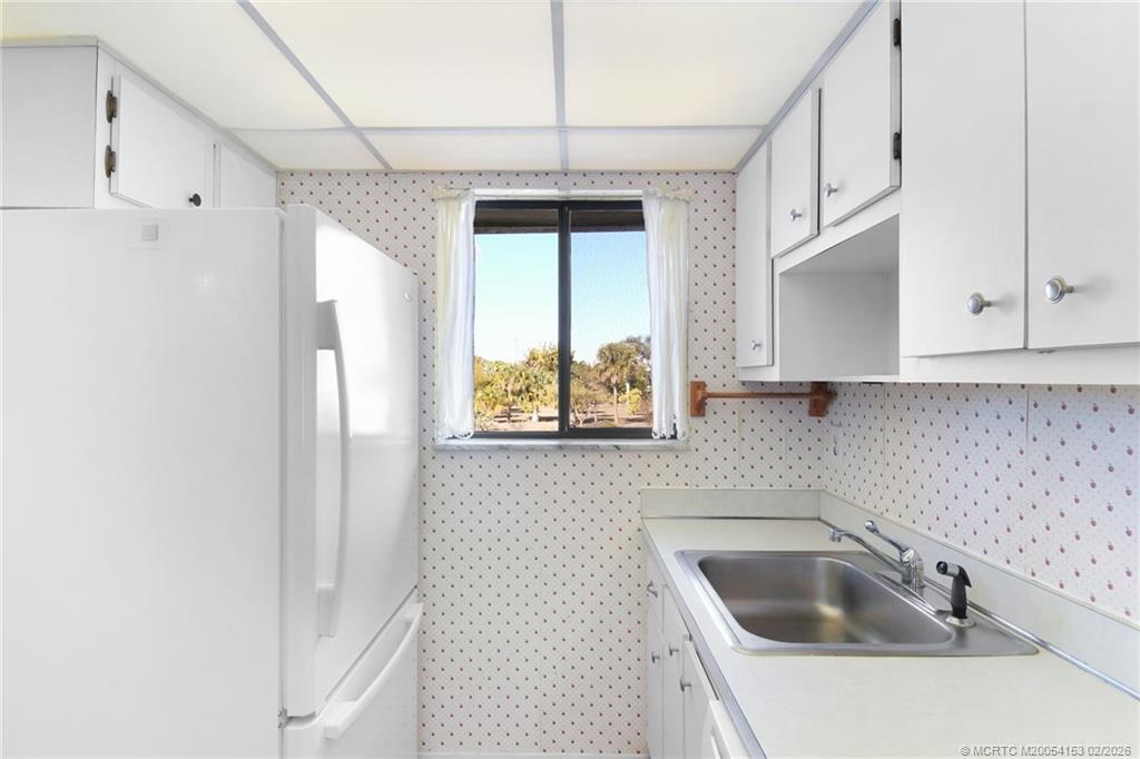 5413 Southeast Miles Grant Road, Unit G206 Stuart, FL 34997 - Photo 6 of 79 a kitchen with stainless steel appliances granite countertop a sink and a refrigerator