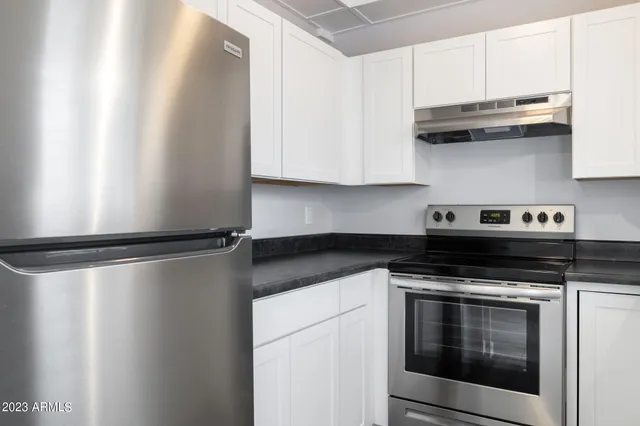 a kitchen with granite countertop white cabinets and white appliances