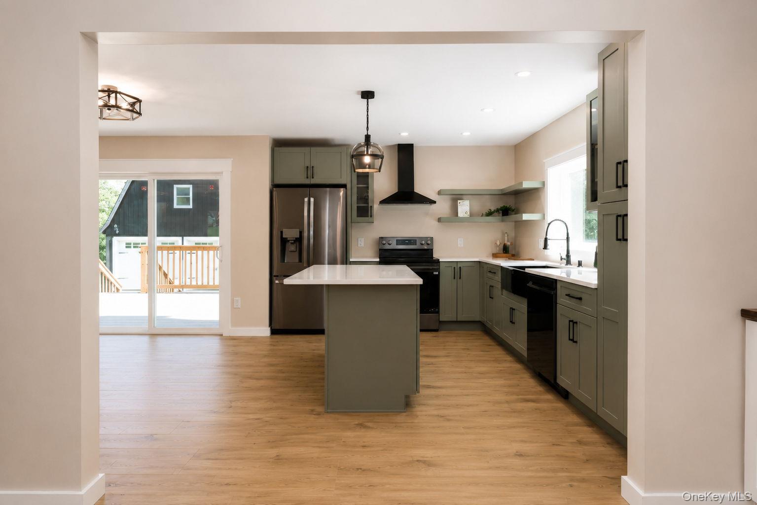 33 County Rte 17 Pine Bush, NY 12566 - Photo 11 of 47 Modern kitchen featuring wood-finish flooring, a central island with a white countertop, sage-toned cabinetry, stainless steel appliances, and a black range hood
