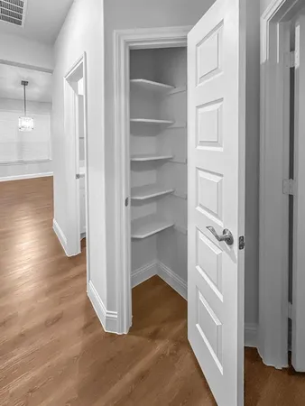 a view of a hallway with wooden floor and closet