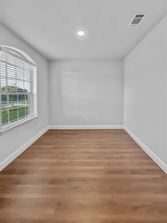 wooden floor in an empty room with a window